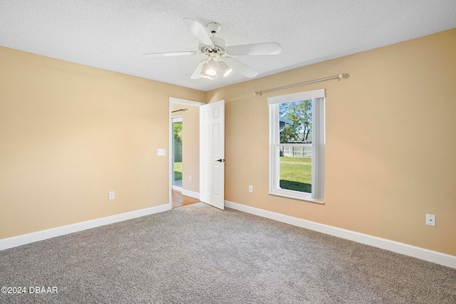 carpeted spare room with a textured ceiling and ceiling fan