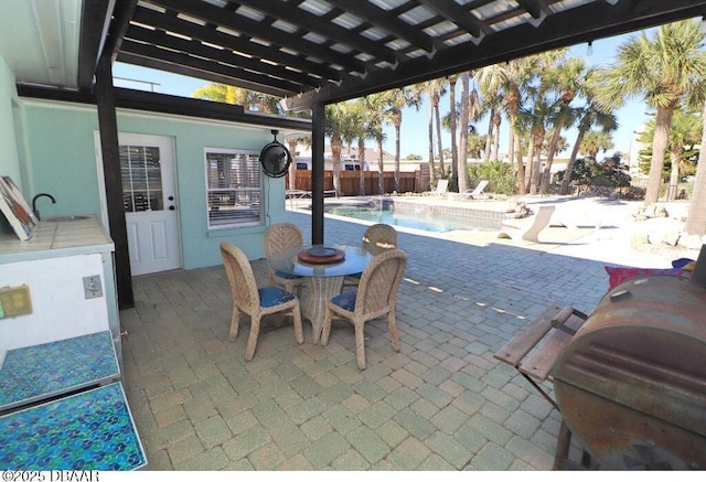 view of patio featuring a fenced in pool, sink, and a pergola