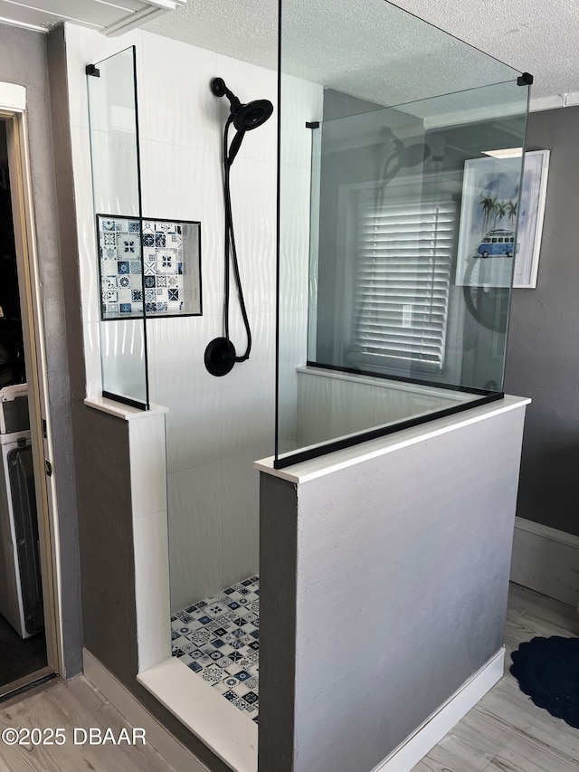 bathroom featuring hardwood / wood-style floors, a textured ceiling, and tiled shower