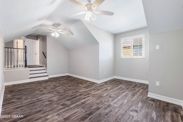 bonus room with ceiling fan, dark hardwood / wood-style floors, a textured ceiling, and lofted ceiling