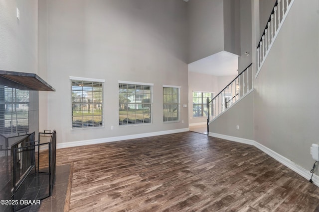 living room with a high ceiling and dark wood-type flooring