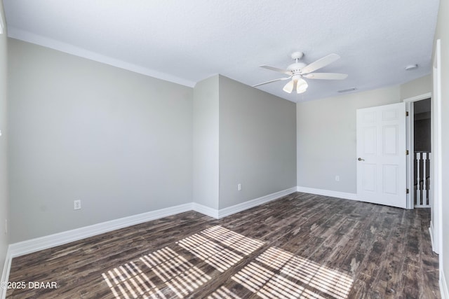 empty room featuring ceiling fan, dark wood-type flooring, and a textured ceiling