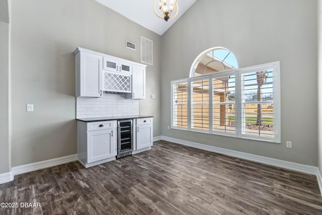 bar featuring decorative backsplash, dark wood-type flooring, white cabinets, and wine cooler