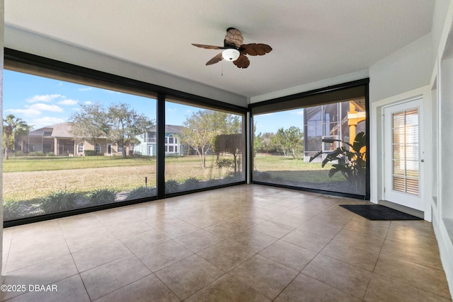 unfurnished sunroom featuring ceiling fan