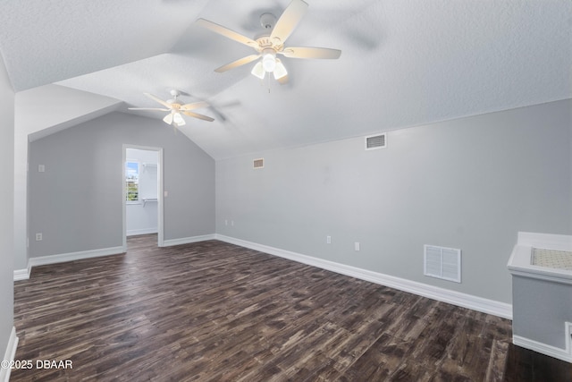 bonus room featuring ceiling fan, dark hardwood / wood-style floors, a textured ceiling, and lofted ceiling