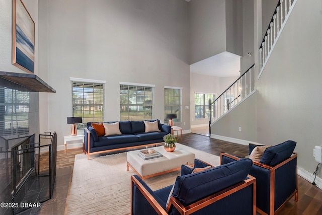 living room featuring dark wood-type flooring and a high ceiling