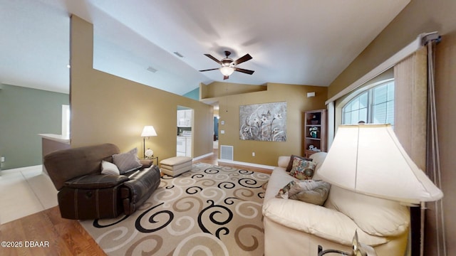 living area with visible vents, vaulted ceiling, baseboards, and ceiling fan