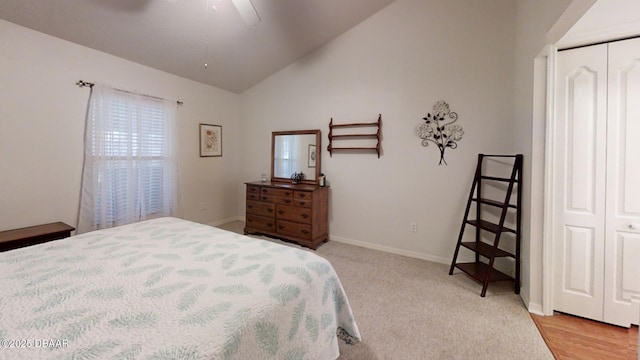 bedroom with a closet, vaulted ceiling, baseboards, and ceiling fan