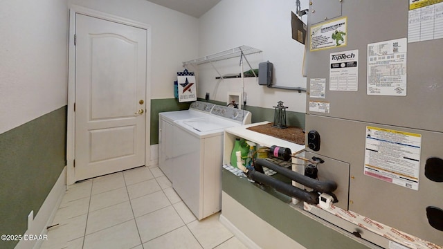 washroom featuring laundry area, washer and clothes dryer, light tile patterned flooring, and heating unit