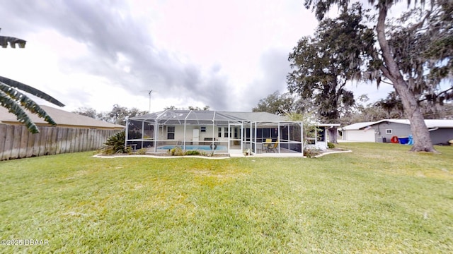 back of property with a lanai, fence, an outdoor pool, and a lawn