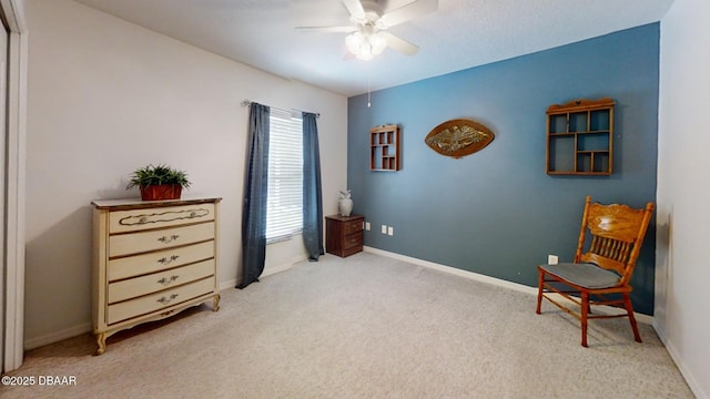 living area with carpet, baseboards, and a ceiling fan