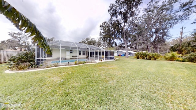 view of yard with glass enclosure, fence, and a fenced in pool