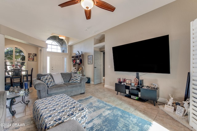 tiled living room featuring ceiling fan and lofted ceiling