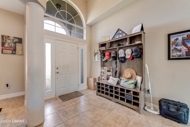 mudroom featuring tile patterned floors and a high ceiling