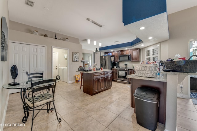 kitchen featuring a breakfast bar, a center island, decorative light fixtures, dark brown cabinets, and stainless steel appliances