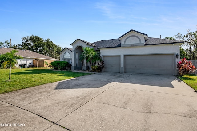 view of front of property with a front yard and a garage