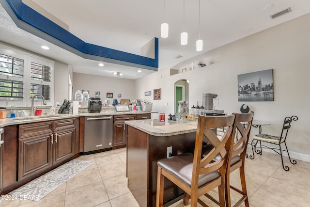 kitchen featuring stainless steel dishwasher, sink, pendant lighting, a center island, and light tile patterned flooring