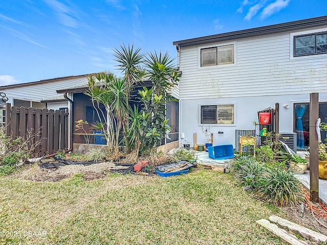 back of house featuring a yard and a sunroom