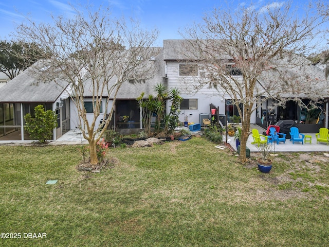 exterior space with a patio area, a sunroom, and a lawn