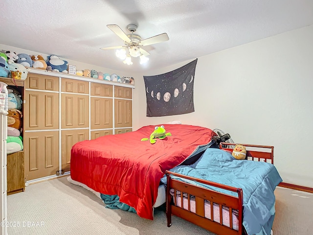 carpeted bedroom with a textured ceiling, ceiling fan, and a closet