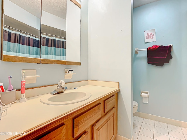 bathroom featuring tile patterned flooring, vanity, a textured ceiling, and toilet