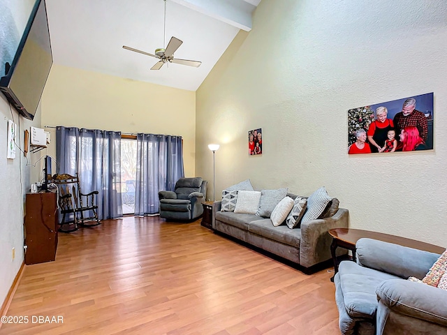 living room with ceiling fan, beam ceiling, high vaulted ceiling, and light wood-type flooring