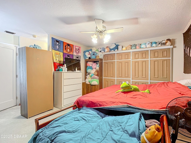 bedroom featuring a closet, ceiling fan, light carpet, and a textured ceiling