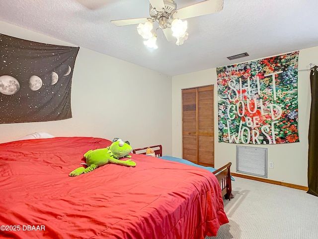 carpeted bedroom with ceiling fan, a closet, and a textured ceiling