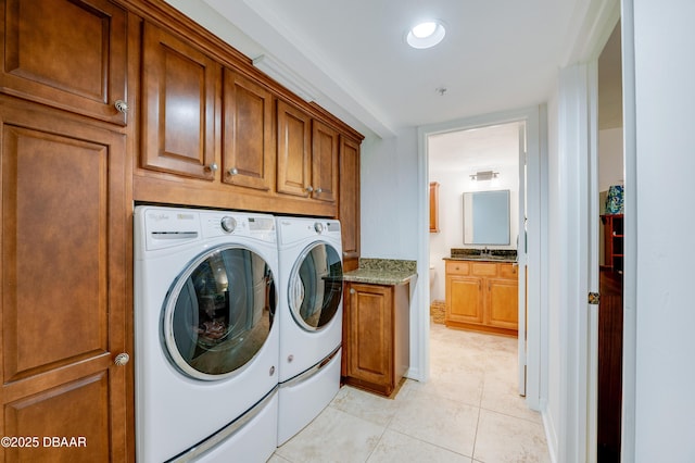 laundry area featuring independent washer and dryer, cabinets, sink, and light tile patterned floors