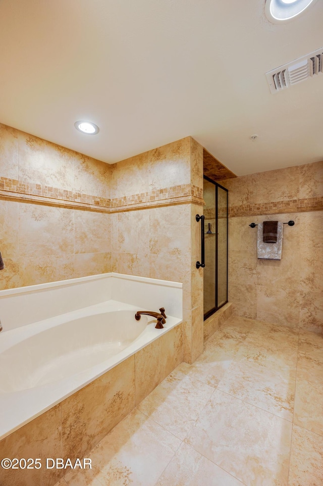 bathroom with tile walls and separate shower and tub