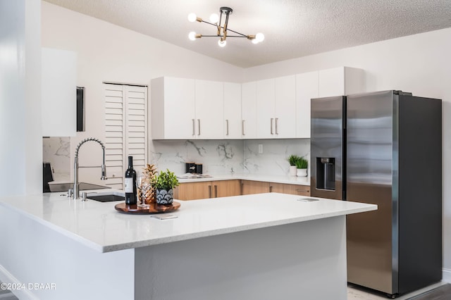 kitchen with vaulted ceiling, light hardwood / wood-style flooring, a textured ceiling, and a notable chandelier