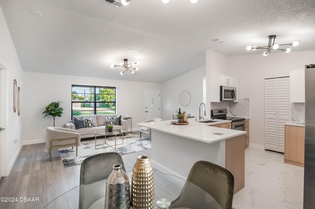 kitchen with vaulted ceiling, light wood-type flooring, stainless steel fridge with ice dispenser, and a chandelier