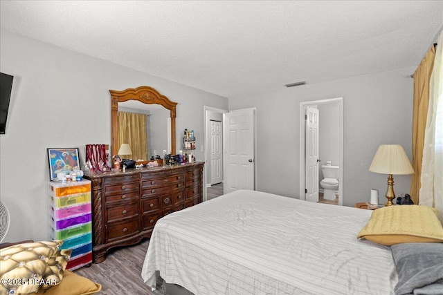 644 Lpga Blvd Unit A, Daytona Beach, FL 32117 - bedroom featuring wood finished floors, ensuite bath, and a textured ceiling