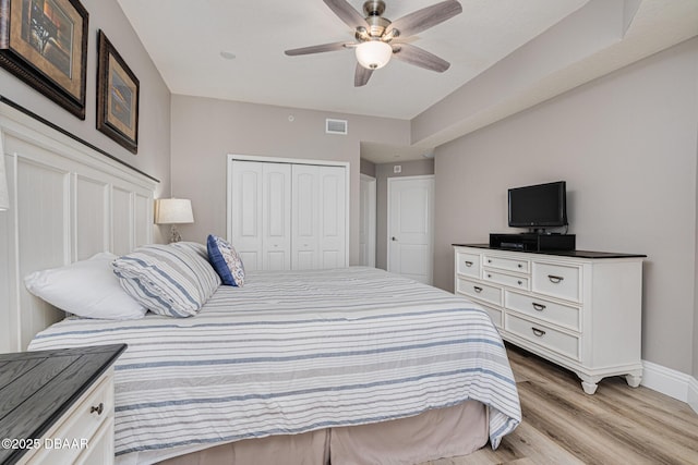 bedroom featuring ceiling fan, a closet, and light wood-type flooring