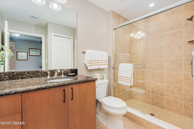 bathroom with vanity, toilet, a shower with shower door, and tile patterned flooring