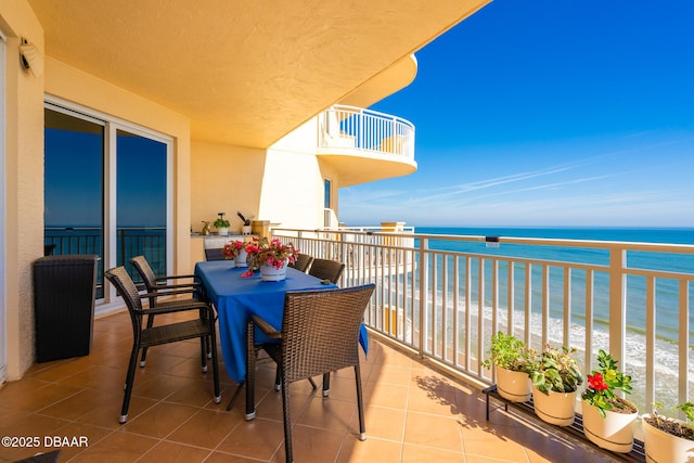 balcony featuring a water view and a view of the beach