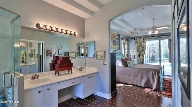 ensuite bathroom with ceiling fan, wood tiled floor, double vanity, ensuite bath, and a sink