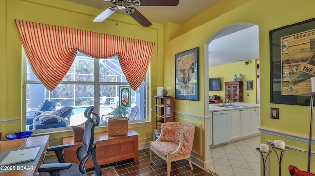 office featuring arched walkways, a ceiling fan, and a sink