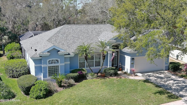 ranch-style home featuring roof with shingles, driveway, stucco siding, a front lawn, and a garage