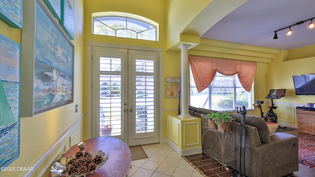 entryway with french doors, tile patterned flooring, rail lighting, and ornate columns