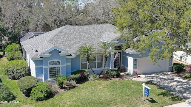 ranch-style home featuring concrete driveway, a front yard, roof with shingles, stucco siding, and an attached garage