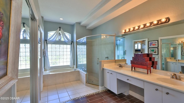 bathroom featuring a shower stall, a bath, double vanity, and a sink