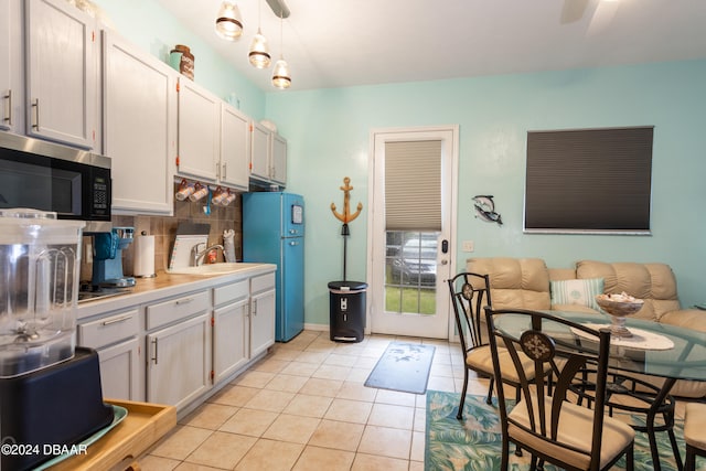 kitchen featuring white cabinetry, sink, appliances with stainless steel finishes, backsplash, and decorative light fixtures