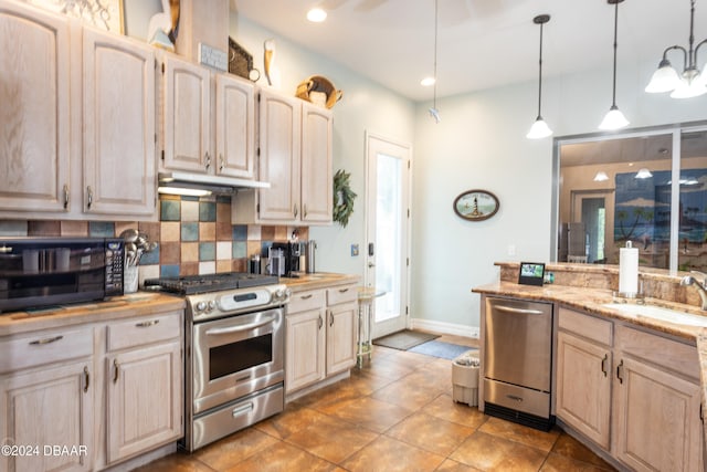 kitchen with hanging light fixtures, light brown cabinets, backsplash, and appliances with stainless steel finishes