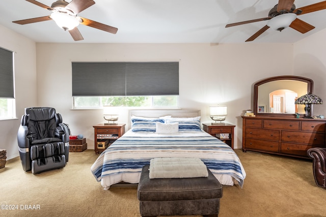 carpeted bedroom featuring ceiling fan and multiple windows