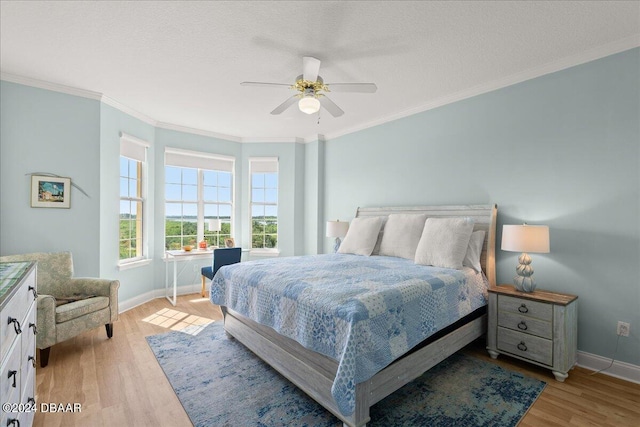 bedroom featuring ornamental molding, light wood-type flooring, a textured ceiling, and ceiling fan