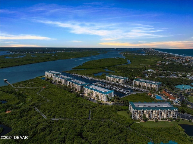 aerial view at dusk featuring a water view