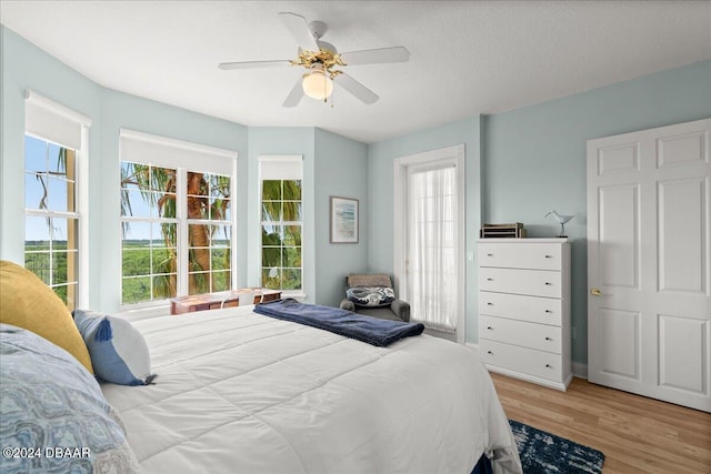 bedroom featuring hardwood / wood-style floors, ceiling fan, and a textured ceiling