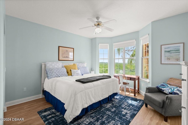 bedroom with a textured ceiling, hardwood / wood-style floors, and ceiling fan