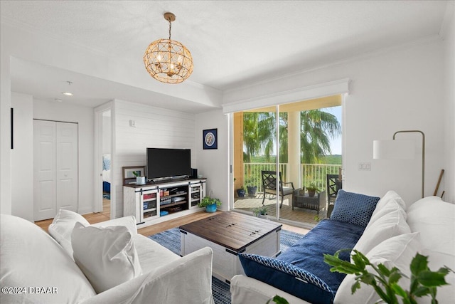 living room with hardwood / wood-style floors, an inviting chandelier, and crown molding